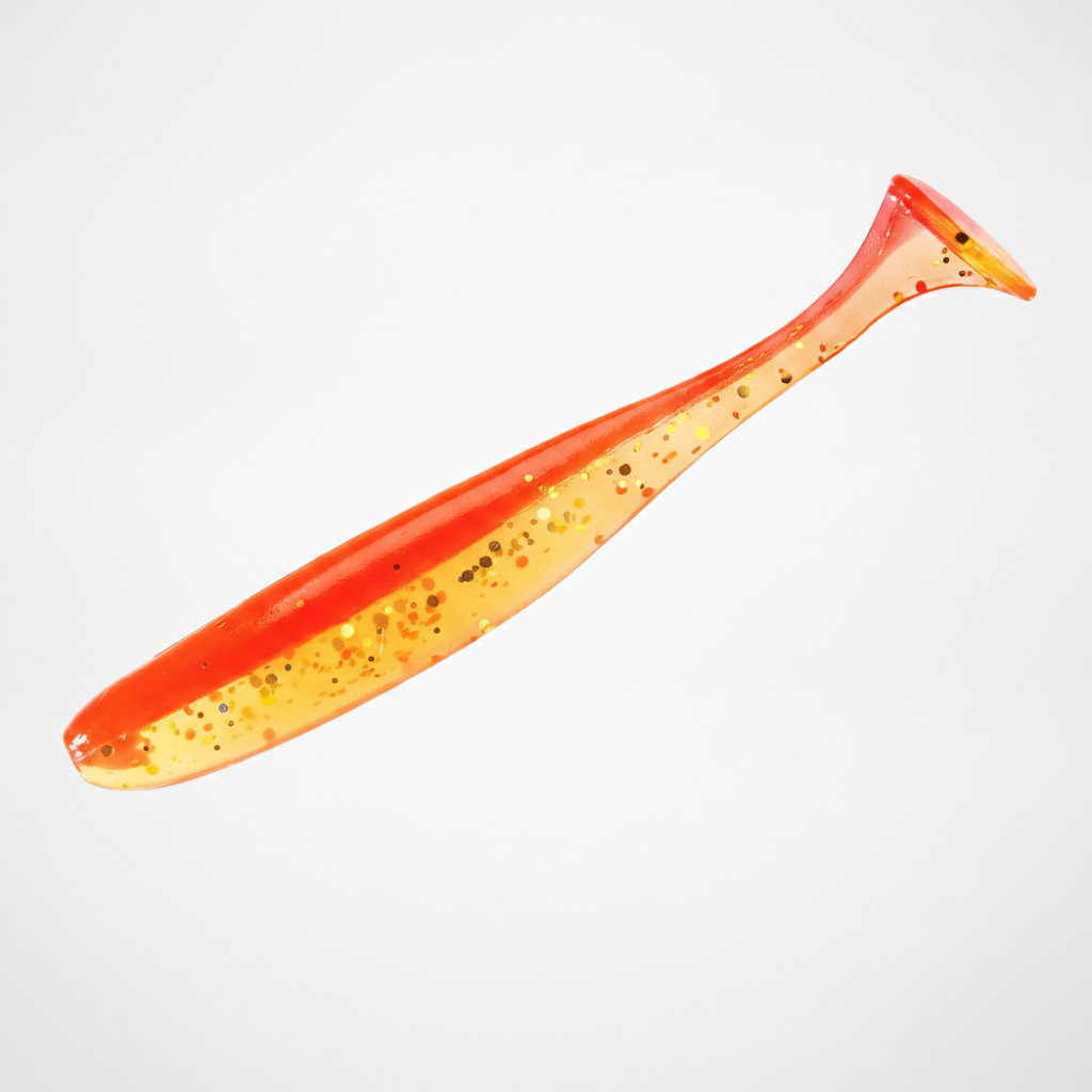 Leurre souple à queue palette coloris orange doré pailleté, packshot studio sur fond blanc.