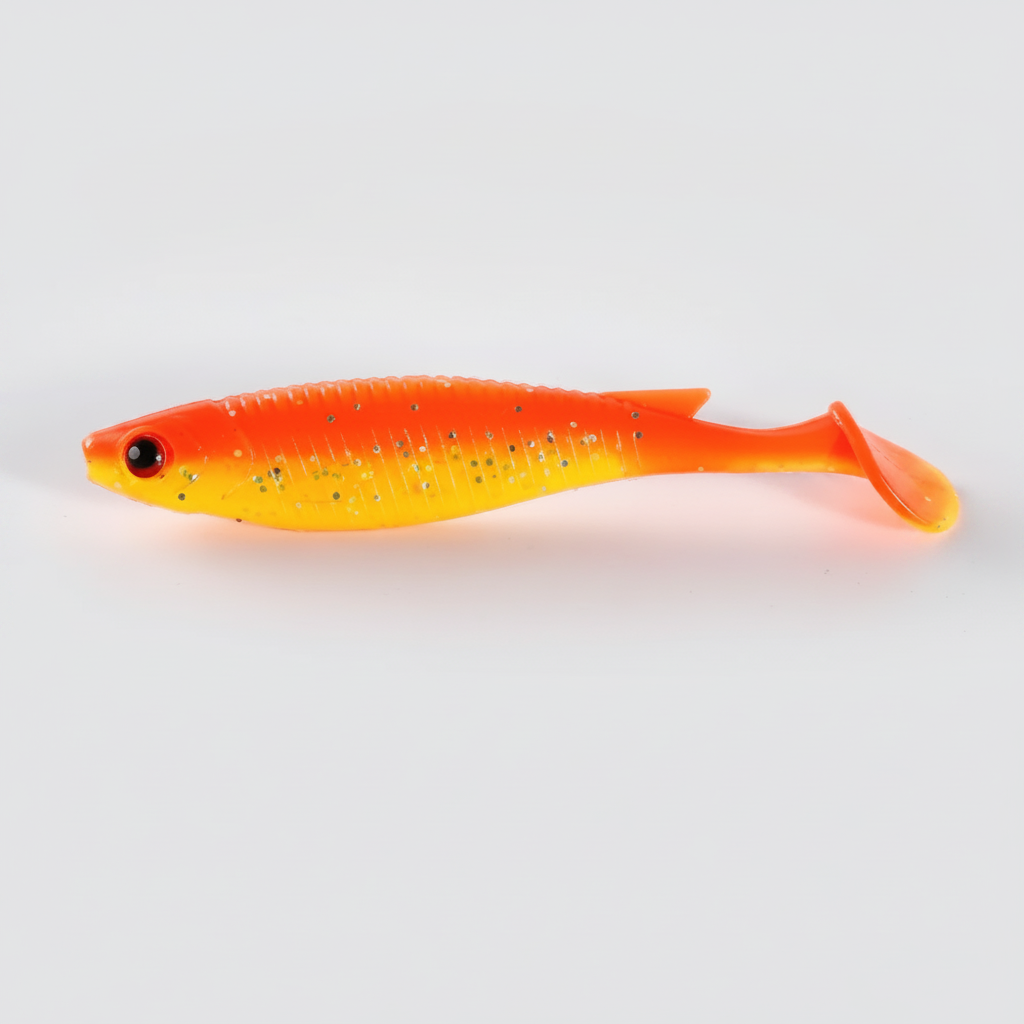 Leurre souple à queue palette, corps strié, coloris orange doré, packshot studio sur fond blanc.